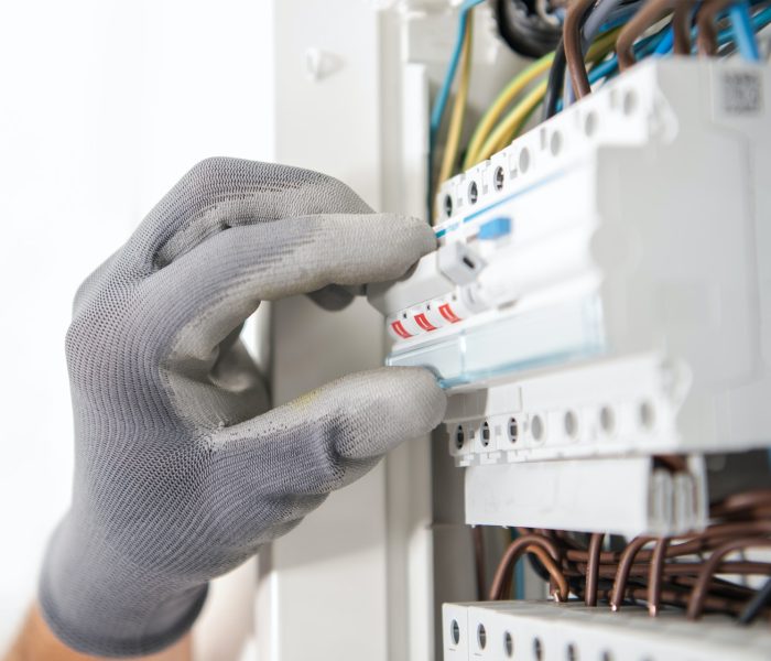 Electrician Testing Fuses In the Electric Box